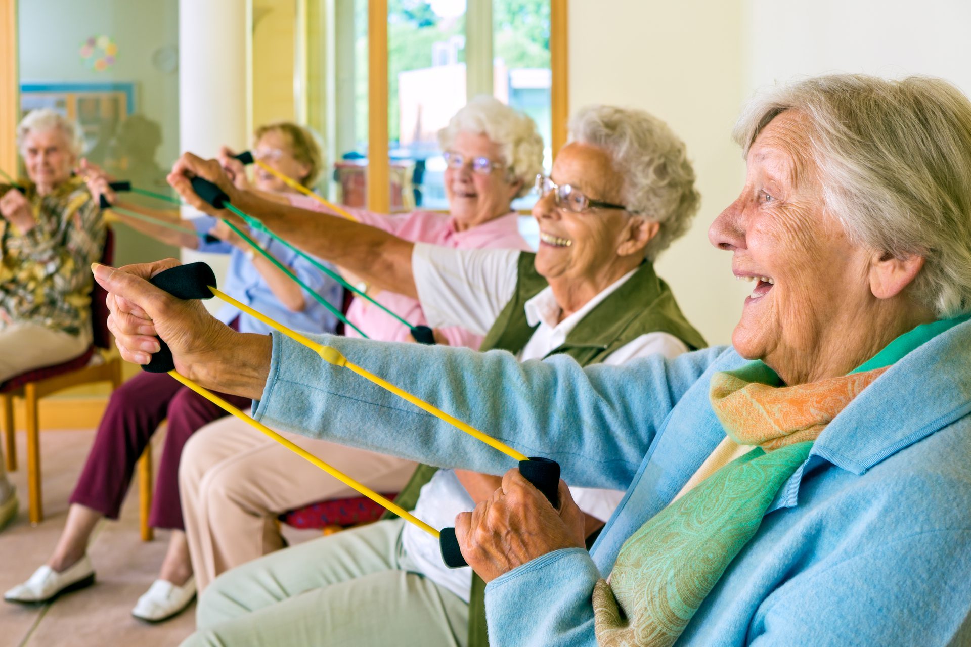 Group of elderly women in a group class with resistance bands.