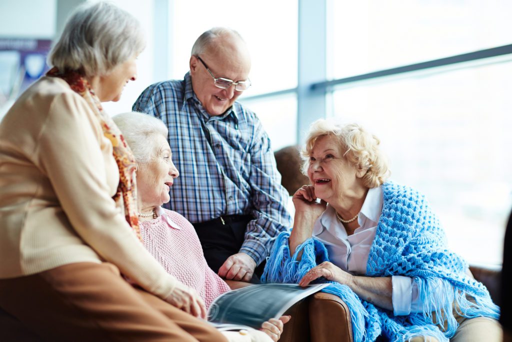 Four older adults sitting together having a conversation.
