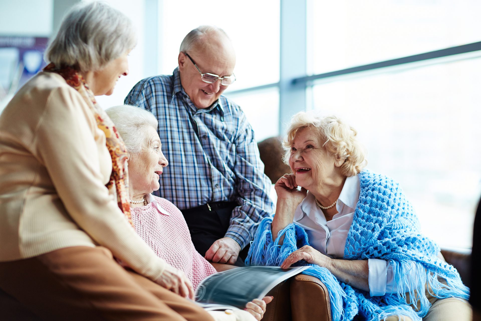 Four older adults sitting together having a conversation.